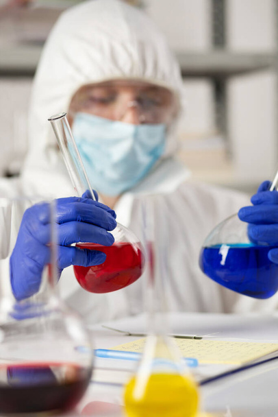 Επιστήμονας που κρατά δοκιμαστικό σωλήνα με υγρό αντιδραστήριο. Εργαστηριακός επιστήμονας και χημικά εργαστηριακά γυάλινα σκεύη - Φωτογραφία, εικόνα