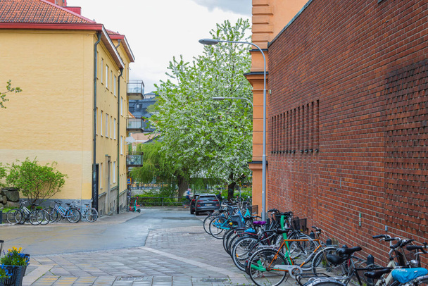 Close up view of bicycle parking on small street in downtown,  Uppsala, Sweden. Healthy lifestyle concept. Sweden. Uppsala. 05.14.2022. - Fotó, kép