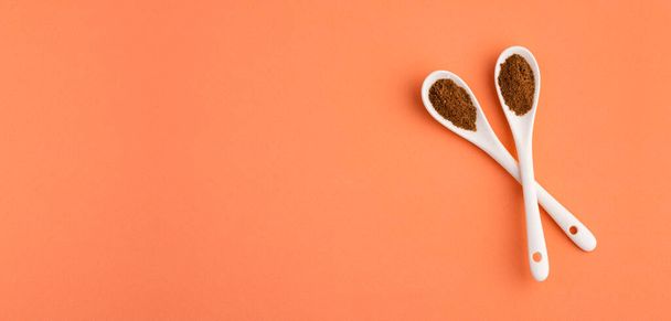 Organic nutmeg powder in two spoons - Myristica - 写真・画像