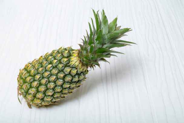 Ananas sur fond de bois blanc, vue de dessus, concept d'alimentation saine aux fruits. - Photo, image