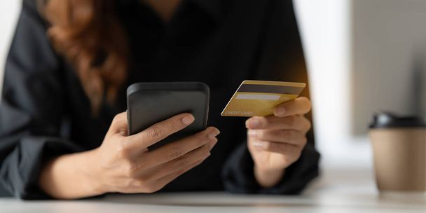 Жінка використовує онлайн-платіж і тримає кредитну картку. Концепція інтернет магазинів
 - Фото, зображення