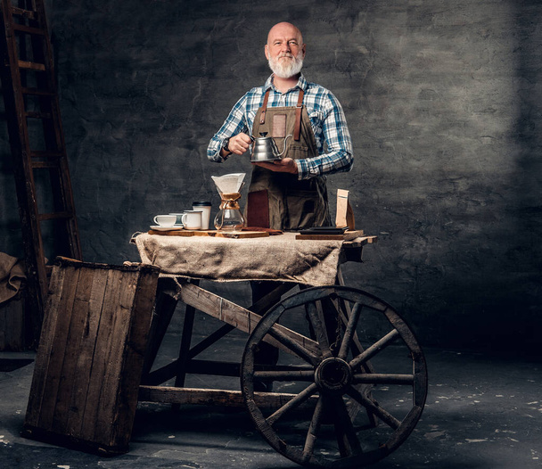 Tiro de barbudo e careca barista posando em torno de carro à moda antiga com máquina de café. - Foto, Imagem