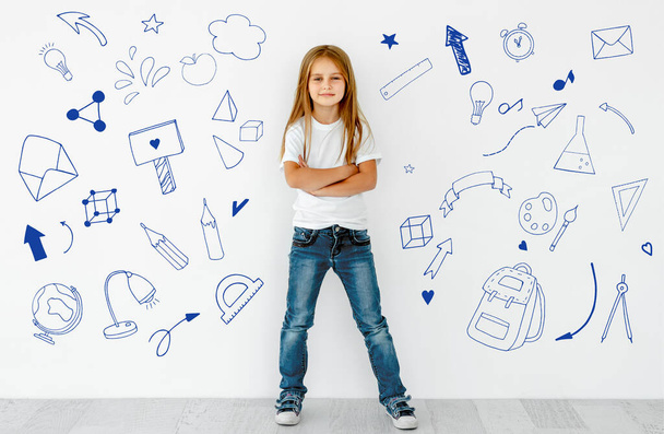Preteen girl with graphic paintings of school elements as concept of knowledge and education. Schollchild person with drawn backpack, globe and envelope as symbol of creativity - Фото, зображення