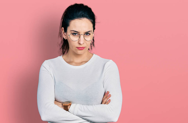 Young hispanic woman wearing casual clothes skeptic and nervous, disapproving expression on face with crossed arms. negative person.  - Photo, Image