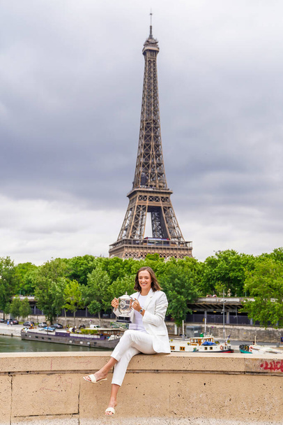 PARÍS, FRANCIA - 5 DE JUNIO DE 2022: 2022 La campeona de Roland Garros Iga Swiatek de Polonia posa con trofeo en el Pont de Bir-Hakeim en París, Francia - Foto, imagen