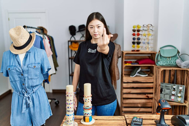Young asian woman working as manager at retail boutique showing middle finger, impolite and rude fuck off expression  - 写真・画像