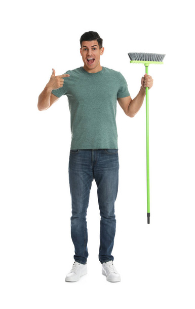 Man with green broom on white background - Foto, Imagen