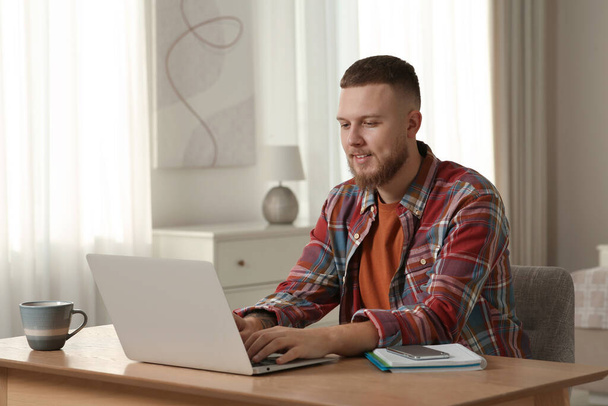Online test. Man studying with laptop at home - Fotografie, Obrázek