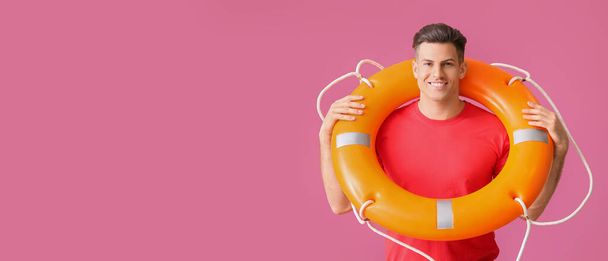 Beach rescuer holding lifebuoy on pink background with space for text - Foto, Imagen