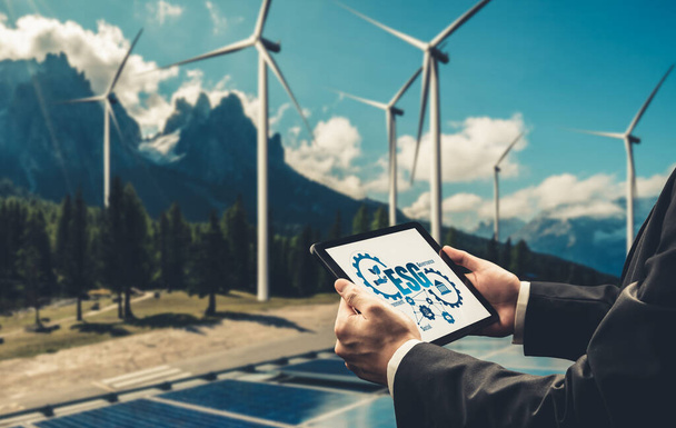 Çevre tasarrufu ve ESG iş konsepti için yeşil iş dönüşümü. İşadamı, çevre dostu yönetime ve alternatif temiz enerji kullanımına yönelik kurumsal bir hedef belirlemek için tablet kullanıyor. - Fotoğraf, Görsel
