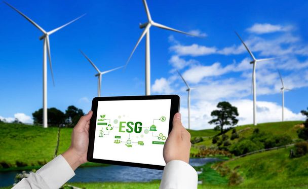 Zöld üzleti átalakulás a környezetvédelemért és az ESG üzleti koncepcióért. Az üzletember táblagépet használ a környezetbarát gazdálkodás és az alternatív tiszta energiafelhasználás vállalati céljainak kitűzésére. - Fotó, kép