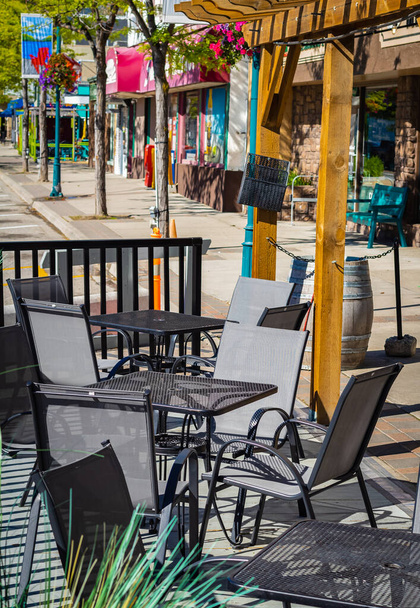 Restaurante vacío terraza de verano con mesas y sillas. Café terraza en la calle peatonal. Reastaurant mesas esperando a los clientes en una terraza al aire libre. Vista de la calle, foto de viaje, nadie - Foto, imagen