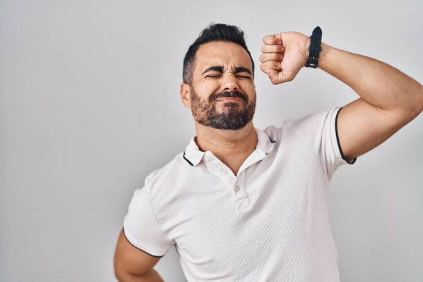 Young hispanic man with beard wearing casual clothes over white background stretching back, tired and relaxed, sleepy and yawning for early morning  - Foto, Imagen