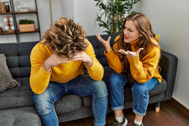 Young caucasian couple arguing sitting on sofa at home - Photo, Image
