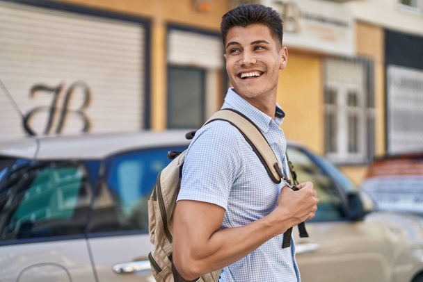 Young hispanic man student smiling confident standing at street - Foto, Bild