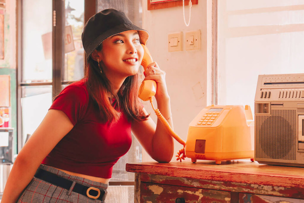 A portrait of a young Asian woman using vintage telephone - Φωτογραφία, εικόνα