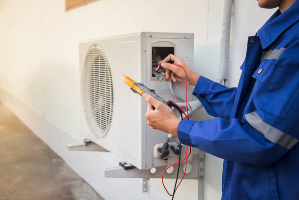 Technicus die de werking van de airconditioner controleert. - Foto, afbeelding
