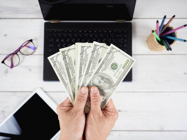 Masa arkası görünümü üzerinde çalışma alanı olan el ele tutuşan para doları - Fotoğraf, Görsel