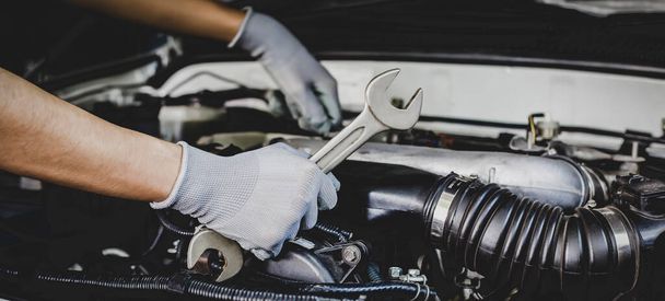 Un mécanicien automobile fait une réparation automobile dans un atelier de réparation. - Photo, image