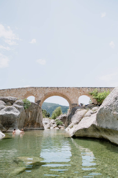 A hidden gem natural pool in Teruel, a region of Spain. This spot is perfect for summer and heatwaves due to high temperatures. Tourists from urban areas come to swim. Roman bridge at the background - Photo, Image