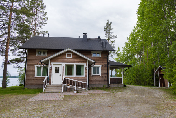 Moderna casa finlandesa de madera a lo largo del lago en gthe coutnryside - Foto, Imagen