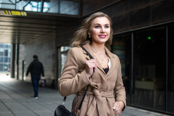 Young smiling woman walking in a city - Φωτογραφία, εικόνα