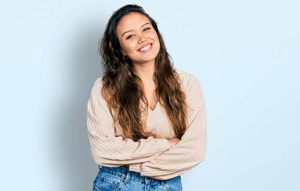 Jong Latijns-Amerikaans meisje met casual kleding vrolijk gezicht glimlachend met gekruiste armen kijkend naar de camera. positieve persoon.  - Foto, afbeelding