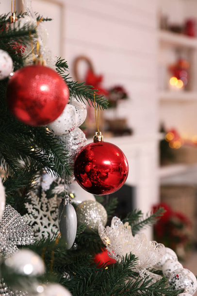 Beautiful Christmas tree with baubles in room, closeup. Interior design - Foto, afbeelding