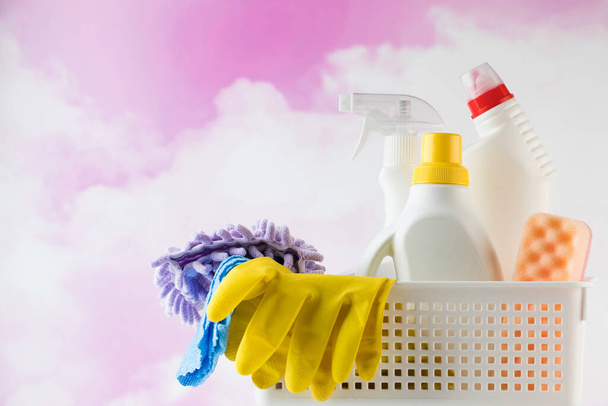  Cleaning products for cleaning, disinfection at home in a basket on the pink clouds. The concept of a cleaner, cleaning company.  - Fotografie, Obrázek