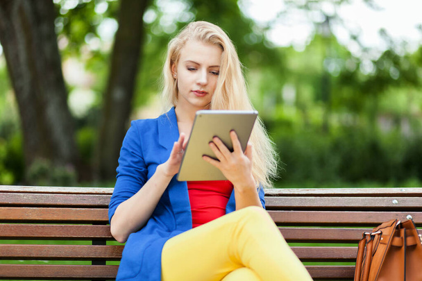 Young businesswoman using tablet computer at park  - Foto, Bild