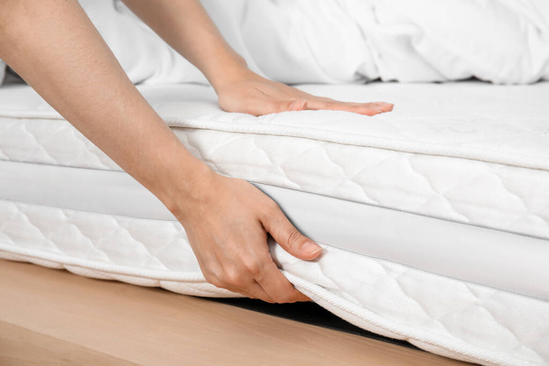 Woman touching soft white mattress on bed, closeup - Foto, imagen
