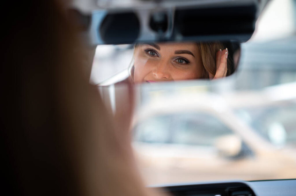 Young lady driving her car reflected in the rear view mirror - Foto, Imagem