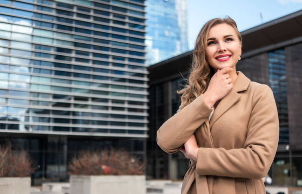 Confident businesswoman portrait outdoor in front of modern glass buildings - Fotoğraf, Görsel