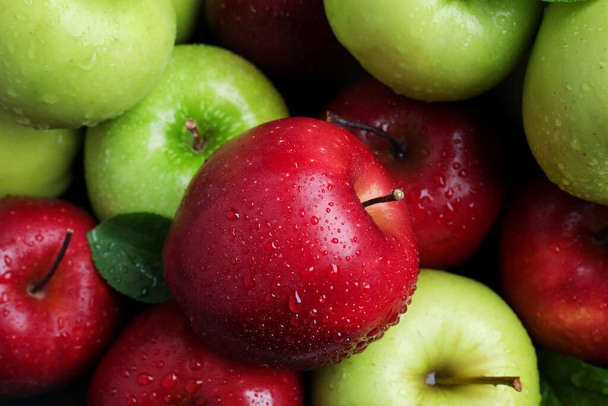 Fresh ripe green and red apples with water drops as background, top view - Photo, Image