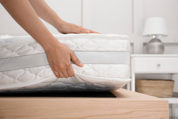 Mujer poniendo colchón blanco suave en la cama en el interior, primer plano - Foto, imagen