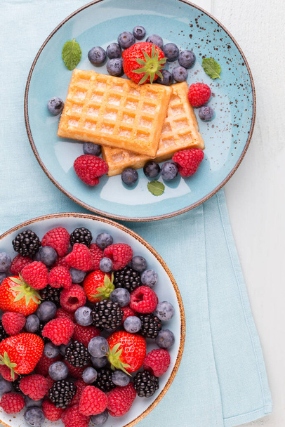 Fresh berries salad in a plate on a  wooden background. Flat lay, top view, copy space. - Photo, Image