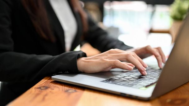Close-up image, Kobieta pracownik biurowy lub businesswoman pracuje nad projektem na laptopie, wpisując na klawiaturze, przeglądając internet w biurze. - Zdjęcie, obraz