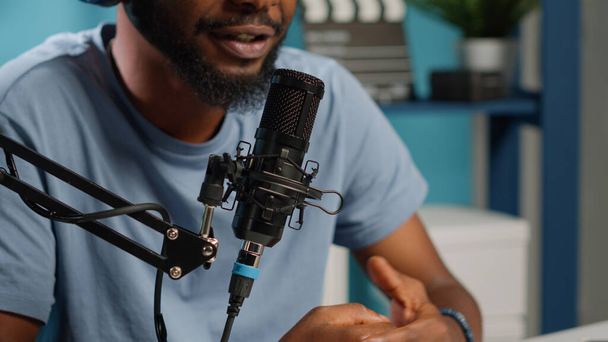 Close up of influencer using microphone to talk on online podcast in studio. Vlogger talking to subscribers while using modern equipment for social media content. Blogger with channel - Foto, Imagem