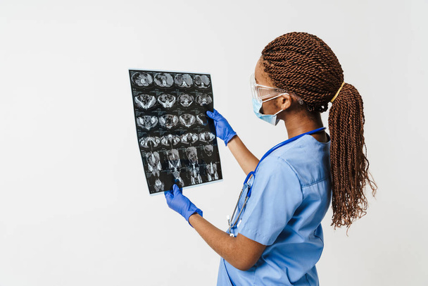 Musta raskaana oleva lääkäri yllään kasvonaamio poseeraa röntgenkuva eristetty valkoisella taustalla - Valokuva, kuva