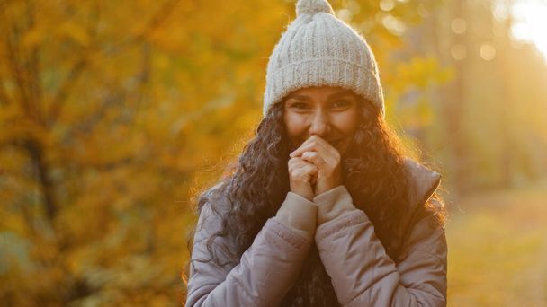 Close-up young pretty hispanic woman looking at camera smiling beside herself with happiness attractive curly girl stands in autumn park poses outdoors in sunshine rejoices laughs enjoys feeling joy - Foto, afbeelding