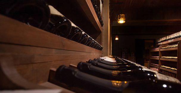 Sparkling wine bottles inside an underground cellar - Zdjęcie, obraz
