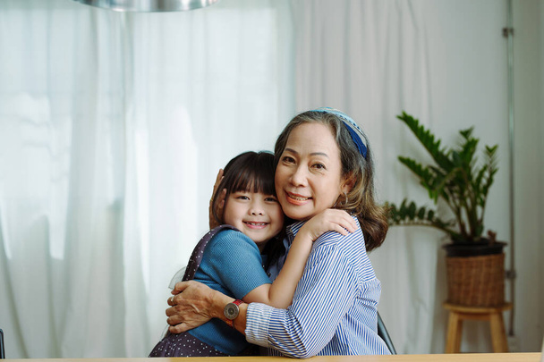 Asian portrait, grandma and granddaughter doing leisure activities and hugging to show their love and care for each other. - Valokuva, kuva