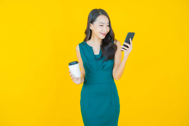 Портрет красивая молодая азиатская женщина улыбка со смартфона на цветном фоне - Фото, изображение