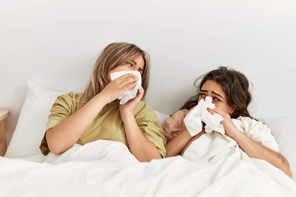 Young ill couple using napkin lying on the bed at home. - Photo, Image