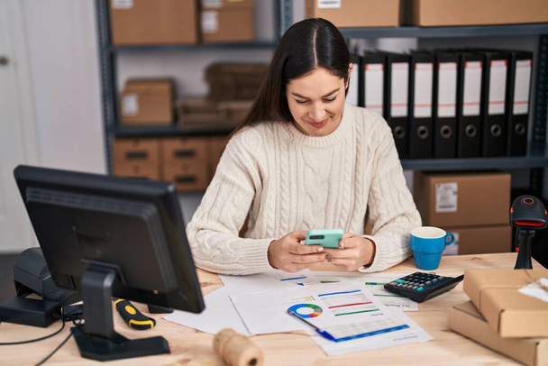 Young woman ecommerce business worker using smartphone at office - Foto, afbeelding