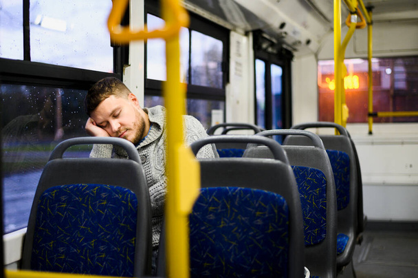 Młody mężczyzna śpi w autobusie. Zdjęcie w wysokiej rozdzielczości - Zdjęcie, obraz