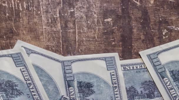 100 dolarových bankovek seřazených na hnědém stole - Záběry, video