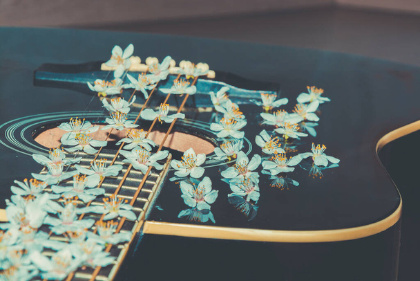 Музыкальный инструмент в цвете. Романтическая гитара. Мелодичный инструмент с цветами - Фото, изображение