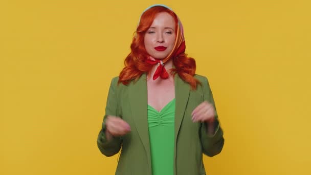 Excited amazed ginger woman in green jacket touching head, showing explosion, looking worried and shocked, professional burnout. Looking surprised wow girl isolated alone on yellow studio background - Footage, Video