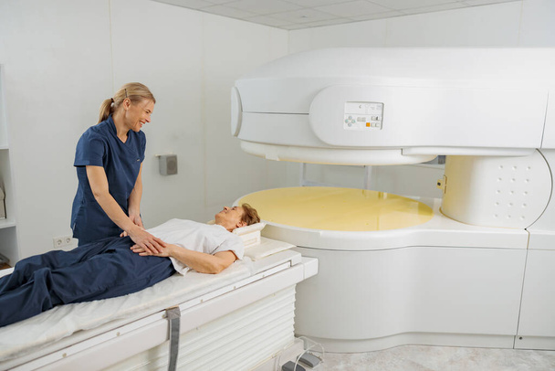 Radiolog kontroluje rezonans magnetyczny lub tomografię komputerową z pacjentem poddanym zabiegowi. Sprzęt medyczny High Tech - Zdjęcie, obraz